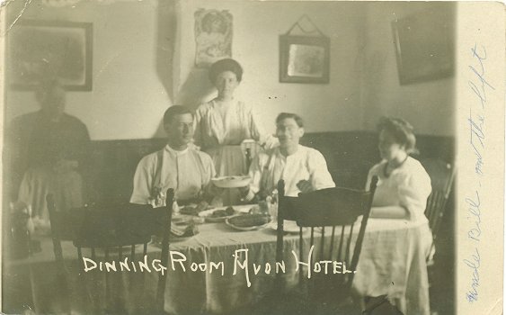 Front of postcard with photograph of Bill Kampa seated in dining room of Avon Hotel.