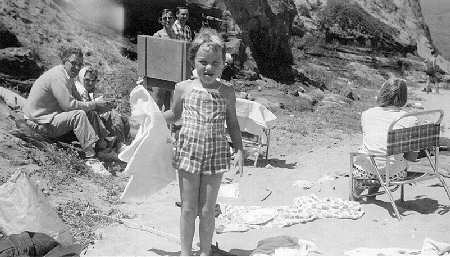 Fran Kampa in swimsuit with her parents in background at left