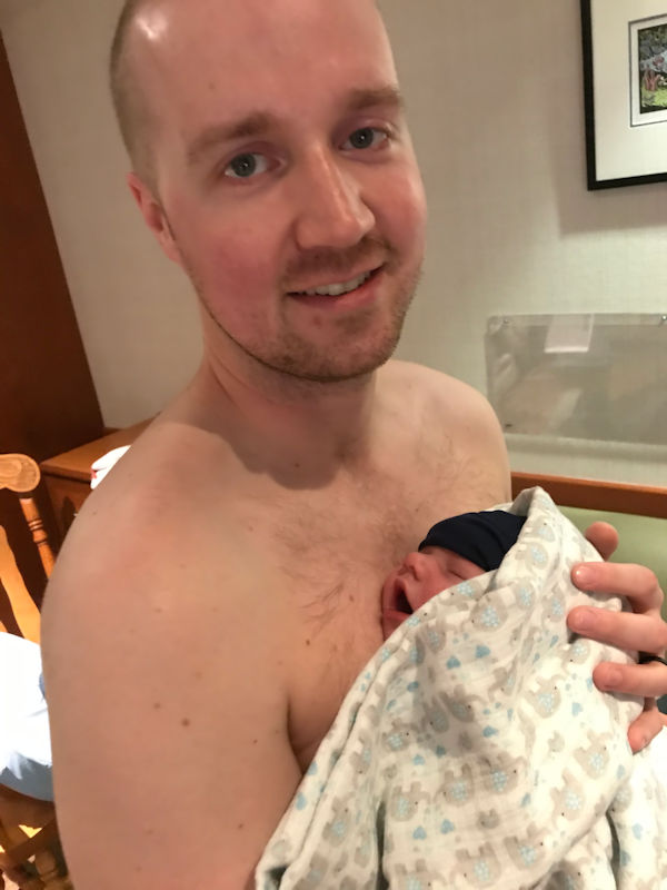 Evan holding his baby daughter, Marit