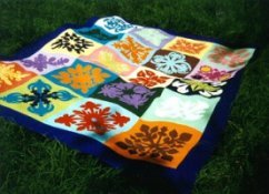 Hawaiian quilt with different blocks featuring variety of floral motifs.