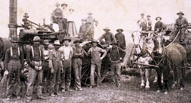 Closeup of people in photograph of Paul Popilek's thresher with two Dziuk boys on the tractor.